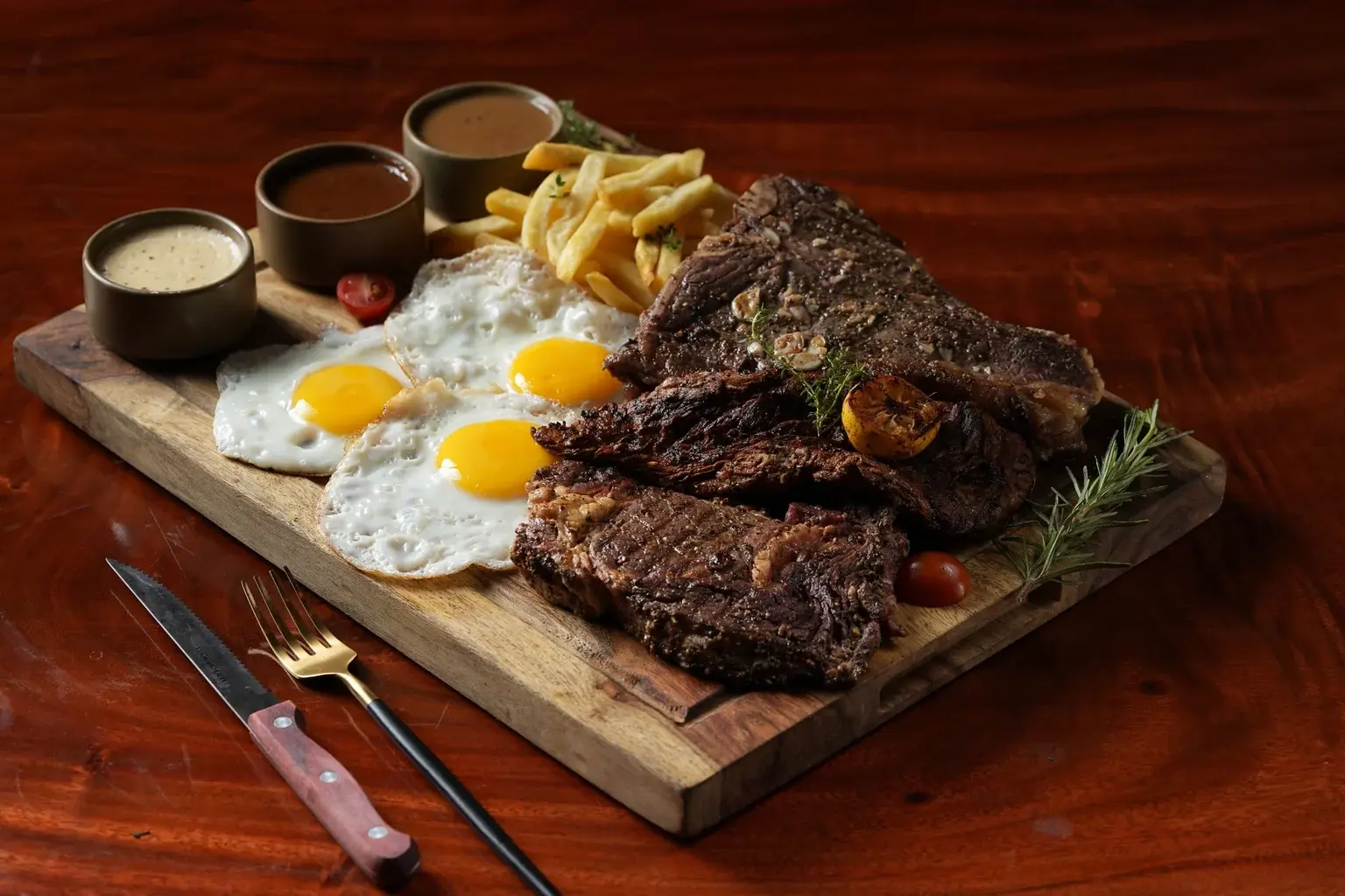 Ninan's steak, fries and sauces plated for a shared table